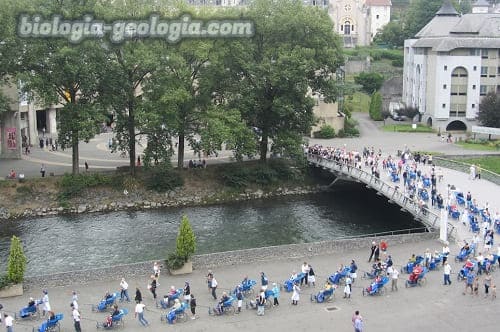 Decenas de persona haciendo cola en el Santuario de Lourdes esperando su cura